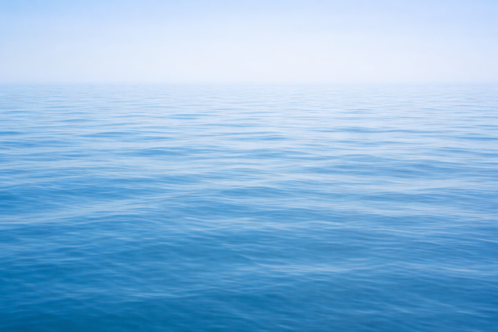 Lähes liikkumaton veden pinta,tasainen valo ja hiljainen tunnelma