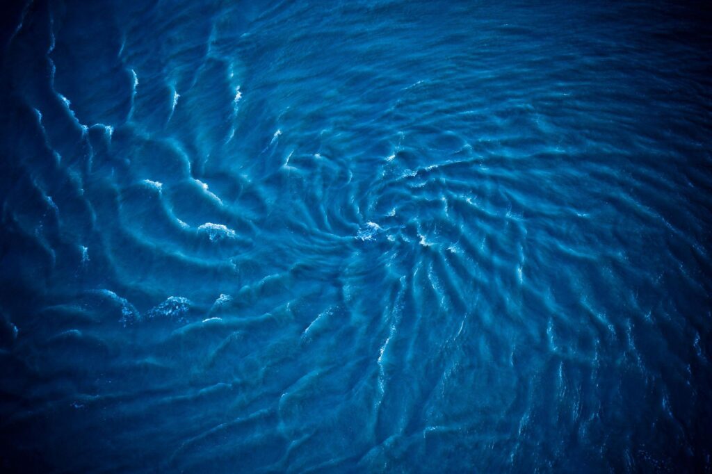 Kirjeitä veden äärellä-II SYVEMPI VESI 1 Vedenalainen pyörivä liike tummassa vedessä,ajaton ja jatkuva liike